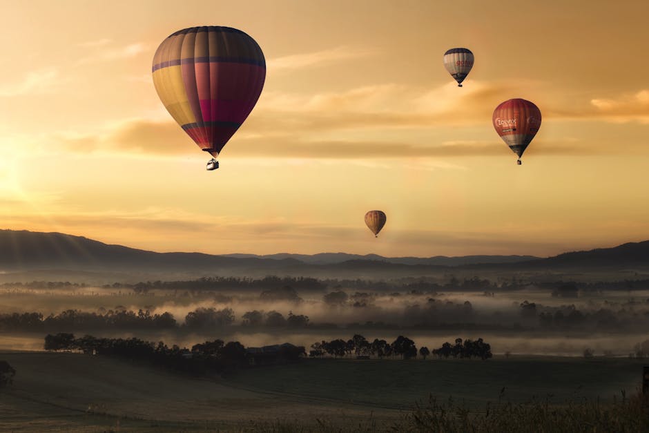 Hot air balloons floating over misty fields at sunrise, creating a picturesque adventure scene