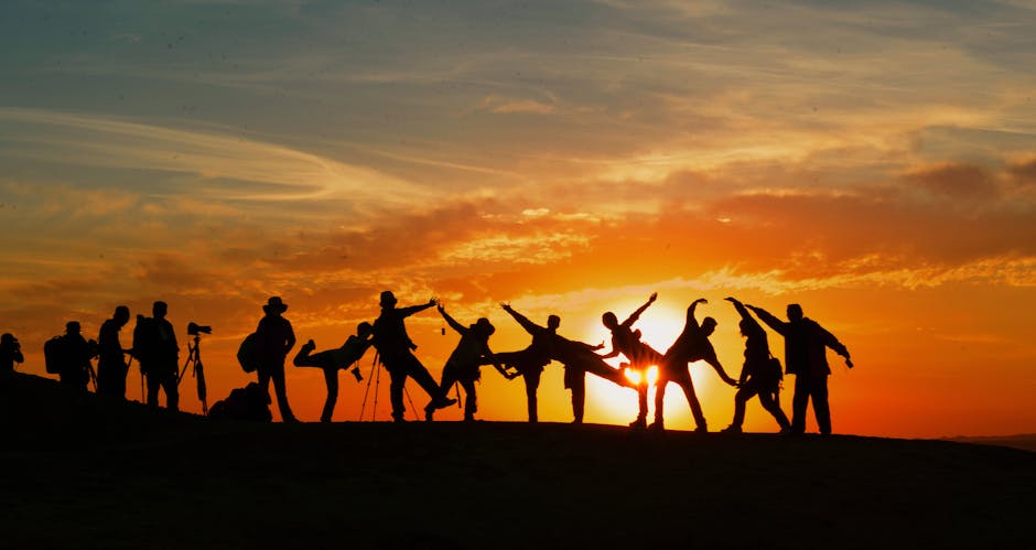 Group of people silhouetted against a vibrant sunset, showcasing unity and joy